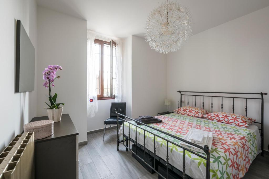 Schlafzimmer mit einem Bett und einem Kronleuchter in der Unterkunft Appartamento Balkissa in San Felice del Benaco