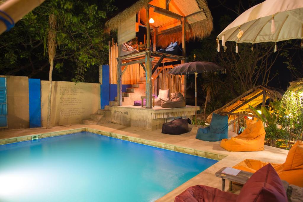 吉利特拉旺安的住宿－吉利拉波希米亞旅館，一座带遮阳伞的房屋前的游泳池