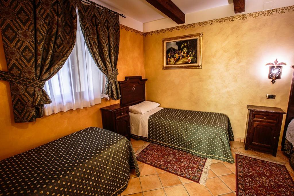 チェラーノにあるHotel Guerrinuccioのベッドルーム1室(ベッド2台、窓付)