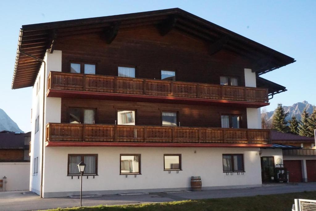 a large wooden building with a balcony at Appartmenthaus am Moosweg in Seefeld in Tirol
