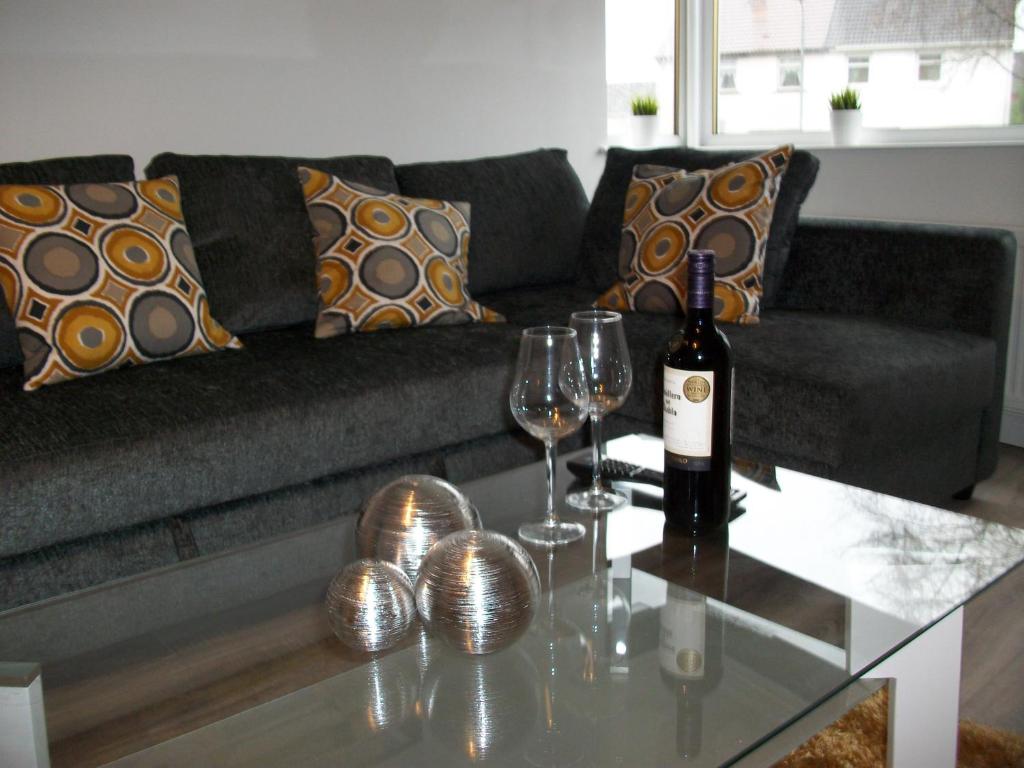 a living room with a couch and a table with wine glasses at Westpark Apartment in East Kilbride
