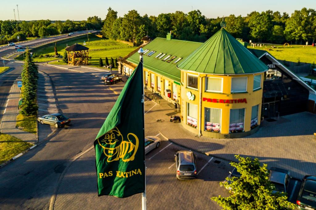 a large building with a green roof and a flag at Hotel Pas Katina in Panevėžys