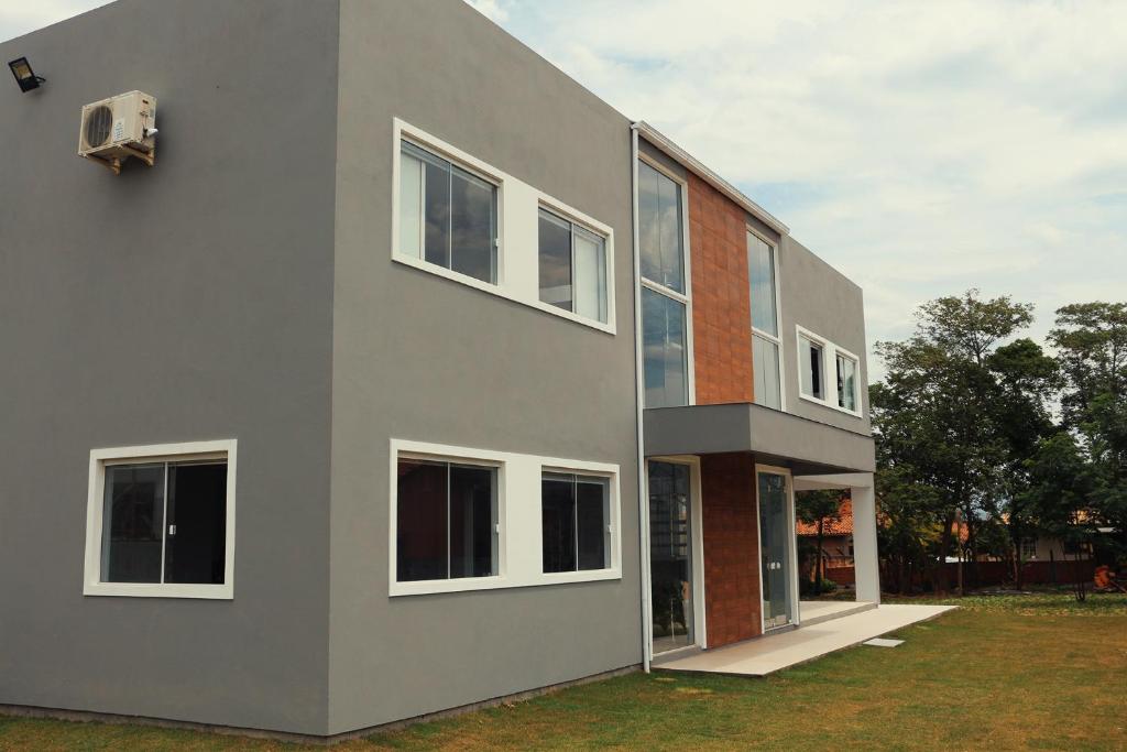 a gray building with windows on the side of it at Rosa Surf Hostel & Food in Praia do Rosa