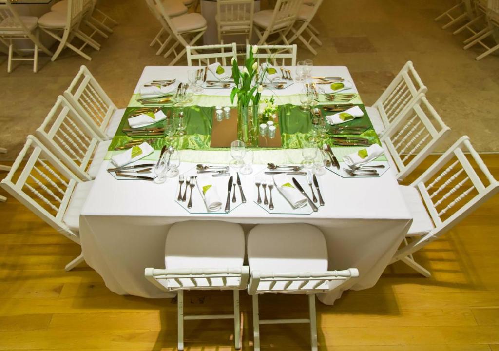 a white table with chairs and plates and glasses at INATEL Caparica in Costa da Caparica