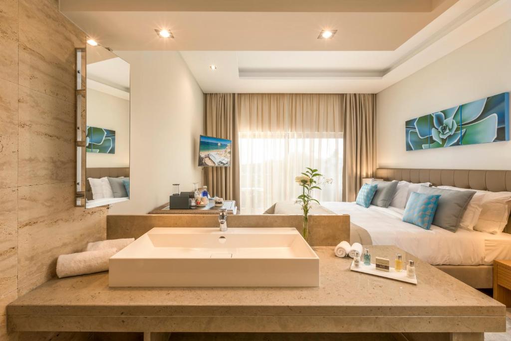 a bathroom with a sink and a bed at Caneiros Luxury House & Suites in Ferragudo