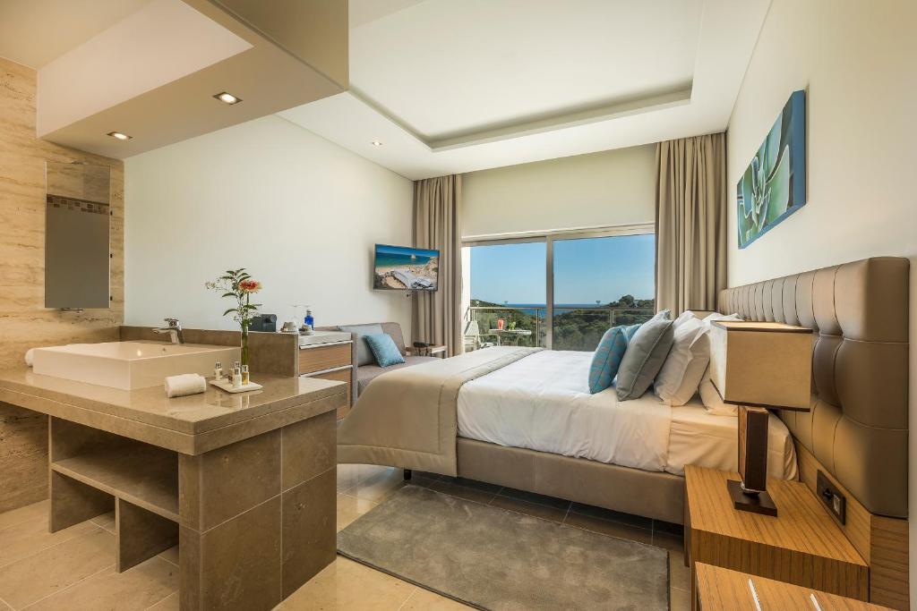 a bedroom with a bed and a tub and a sink at Caneiros Luxury House & Suites in Ferragudo