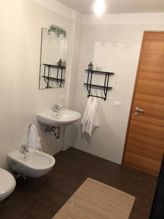 łazienka z umywalką, toaletą i lustrem w obiekcie Apartment Himmelreich w mieście Brunico