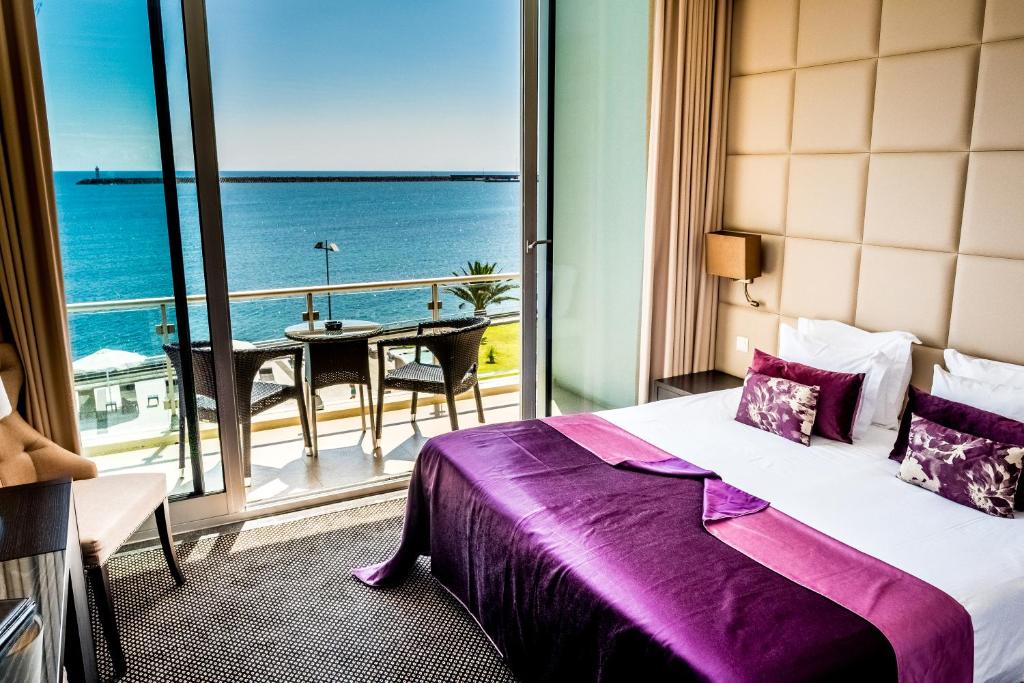 a hotel room with a bed and a view of the ocean at Atlantida Mar Hotel in Praia da Vitória