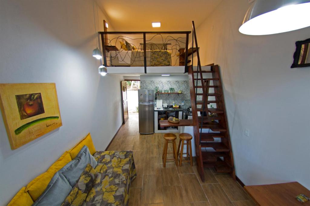 uma sala de estar com escadas que levam a uma cozinha em Casinhas da Julieta em Morro de São Paulo