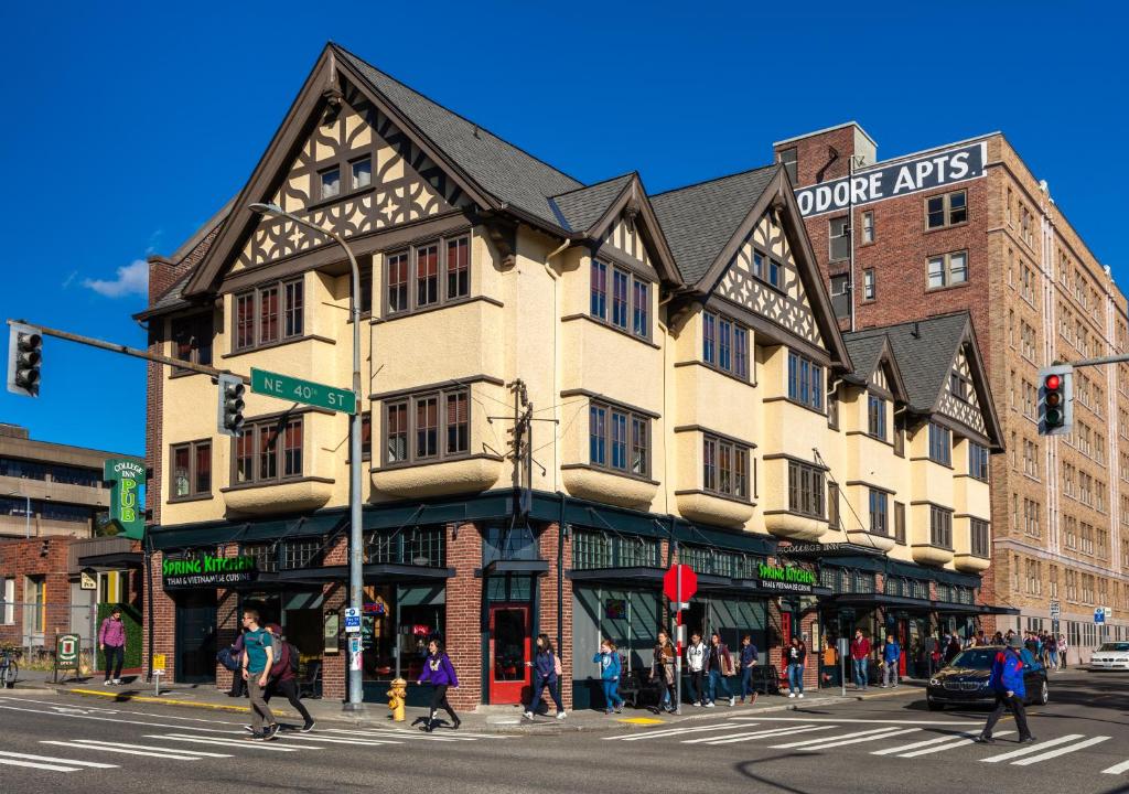 un edificio en la esquina de una calle con gente cruzando la calle en College Inn Hotel, en Seattle