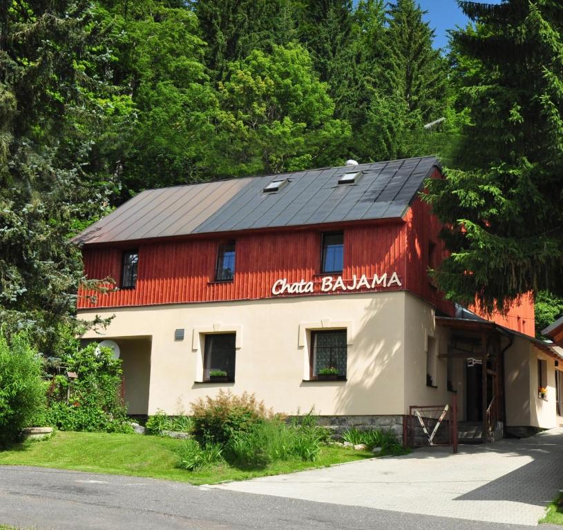 a red and white building with a black roof at Chata Bajama in Bedřichov