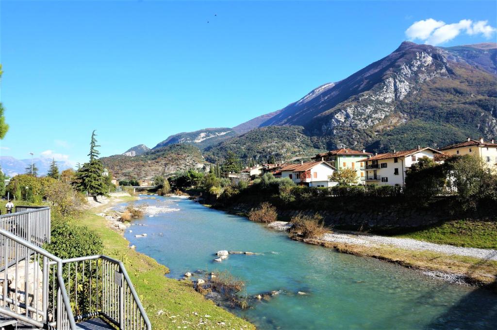 a river with houses and mountains in the background at Primo Passo Apartments in Arco