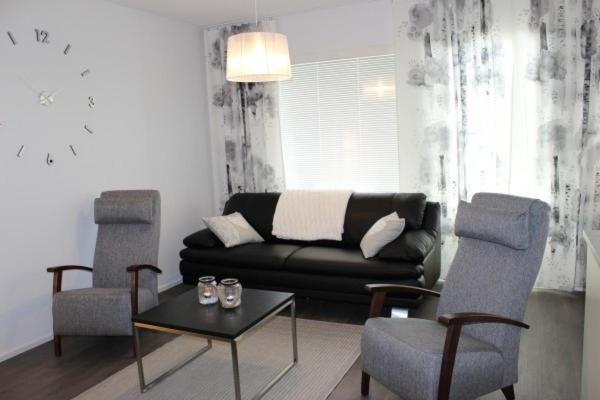 a living room with a couch and two chairs at Majoituspalvelu Nurmi Apartment Yritysperänkatu 2 E 2 (Centre of Raahe) in Raahe