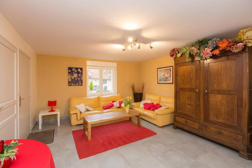 sala de estar con muebles amarillos y alfombra roja en Les Coquelicots, en Marieulles
