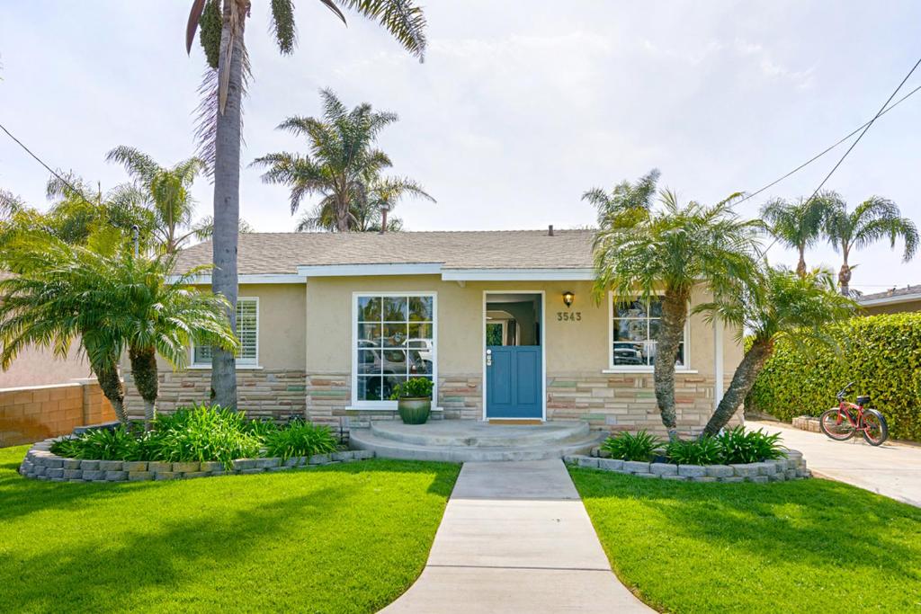 a house with palm trees and a blue door at Ultimate Beach Bungalow - 1 block from beach - huge backyard in Carlsbad