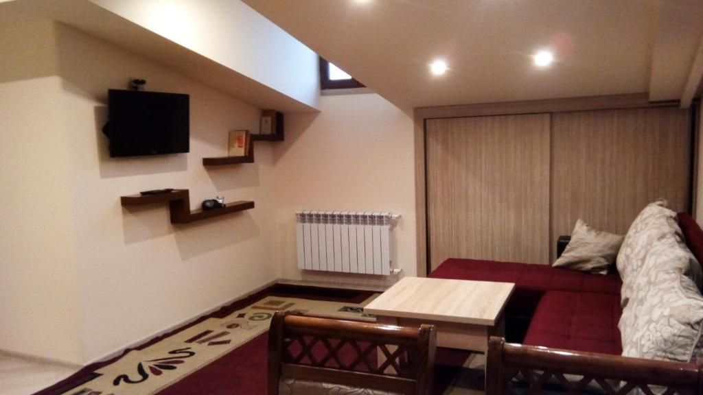 a living room with a red couch and a table at Lily's Apartment in Yerevan