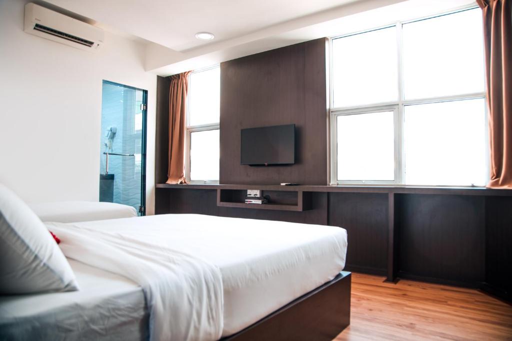 um quarto com uma cama e uma televisão de ecrã plano em Shuang Ling Inn em Miri