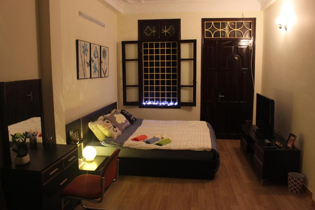 Schlafzimmer mit einem Bett, einem Schreibtisch und einem Fenster in der Unterkunft Amazing stay-homestay, quiet and cozy place LTT Thanh Xuân in Hanoi