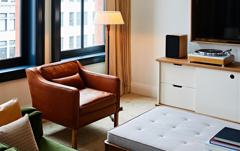 a living room with a chair and a television at Shinola Hotel in Detroit