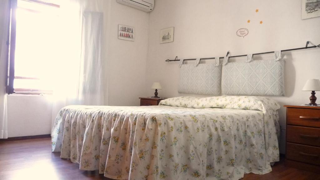 - une chambre dotée d'un lit avec un couvre-lit floral dans l'établissement Casa Gio' - Casa Indipendente con cucina, à Sassari