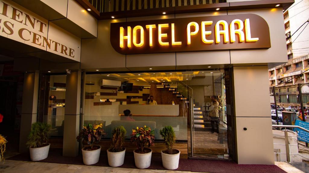Hotel Pearl في فادودارا: لؤة الفندق مع نباتات الفخار أمام متجر