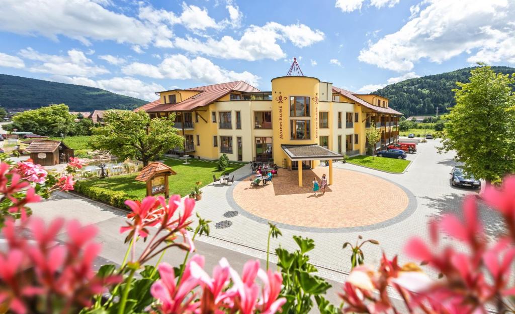ein großes gelbes Gebäude mit einem Park davor in der Unterkunft Hotel Gasthaus Mosers Blume in Haslach im Kinzigtal