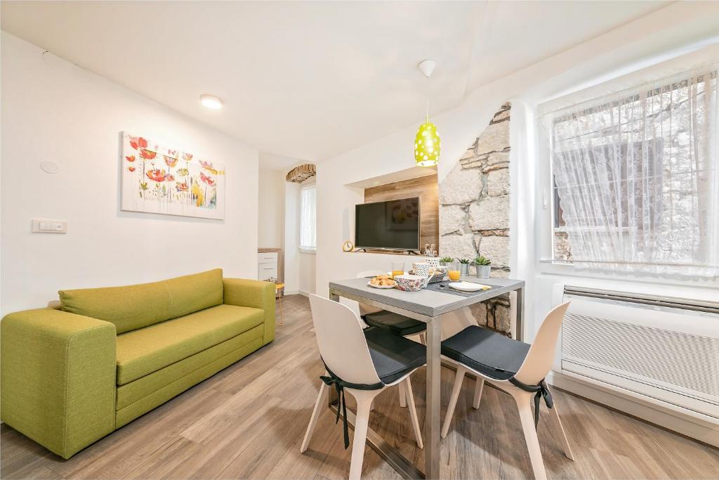 uma sala de estar com um sofá verde e uma mesa em Mariva Downtown apartment with free parking em Rovinj