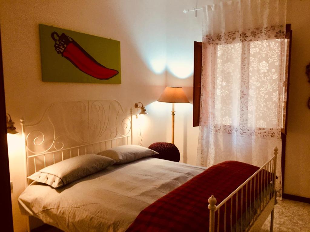 1 dormitorio con 1 cama con una pintura de pimienta roja en la pared en Casa Gamilia, en Nápoles