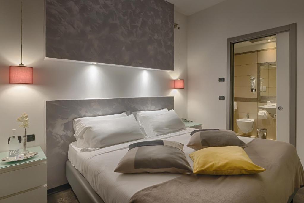 una camera da letto con un grande letto con due cuscini sopra di Hotel Raganelli a Roma