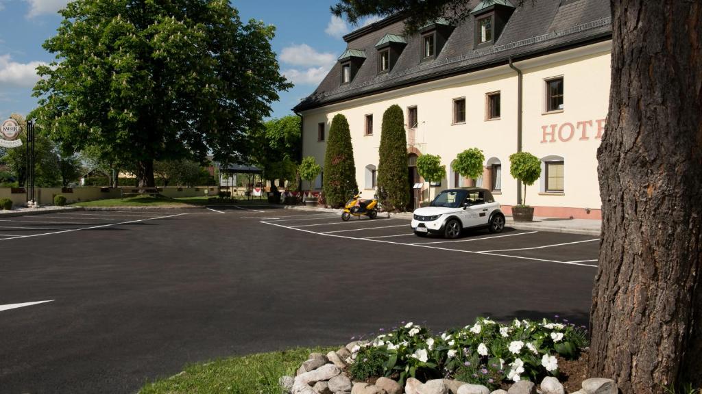 un coche aparcado en un aparcamiento frente a un hotel en Hotel Kaiserhof en Anif