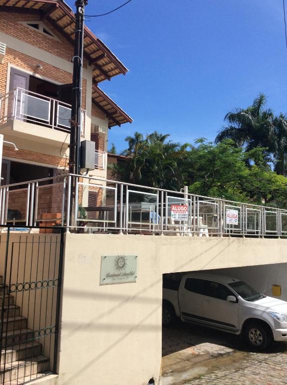 a white van parked under a bridge next to a building at Residencial Annabel Apto 04 in Bombinhas