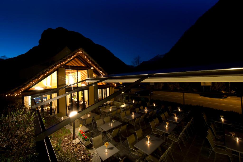 an outdoor dining area at night with lights at MyVerzasca Resort Ai piee in Brione