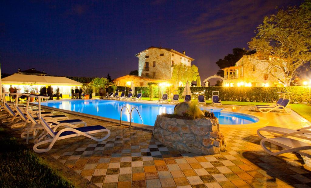 a swimming pool with chairs and a building at night at B&B Villa Corte Degli Dei in Lucca