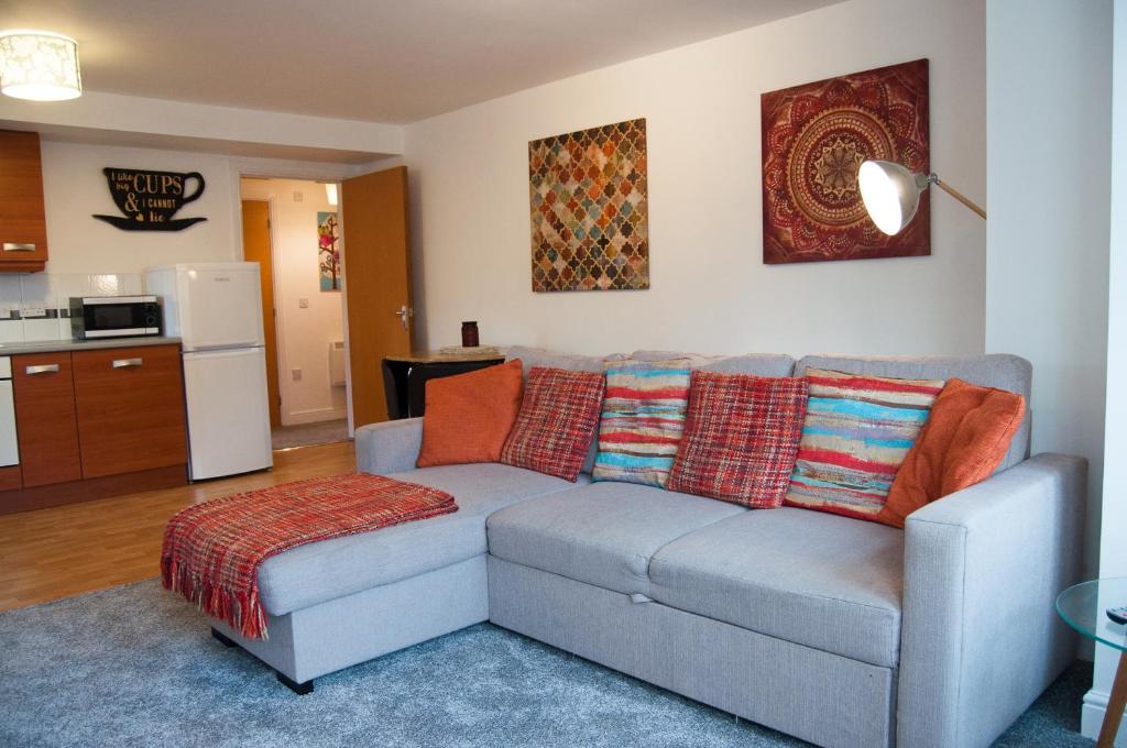 a living room with a couch and a kitchen at Bolton Executive Apartment in Bolton