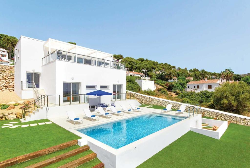 a villa with a swimming pool and a house at Paradise in Son Bou