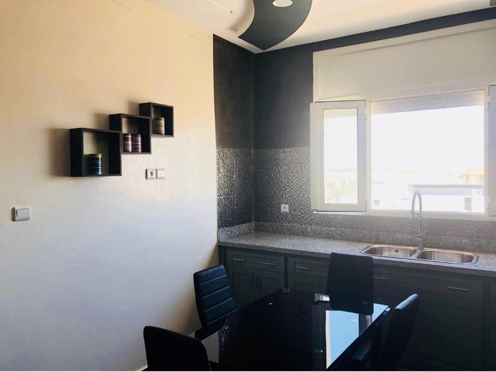 uma cozinha com uma mesa, um lavatório e uma janela em Safiote House appartement em Safi