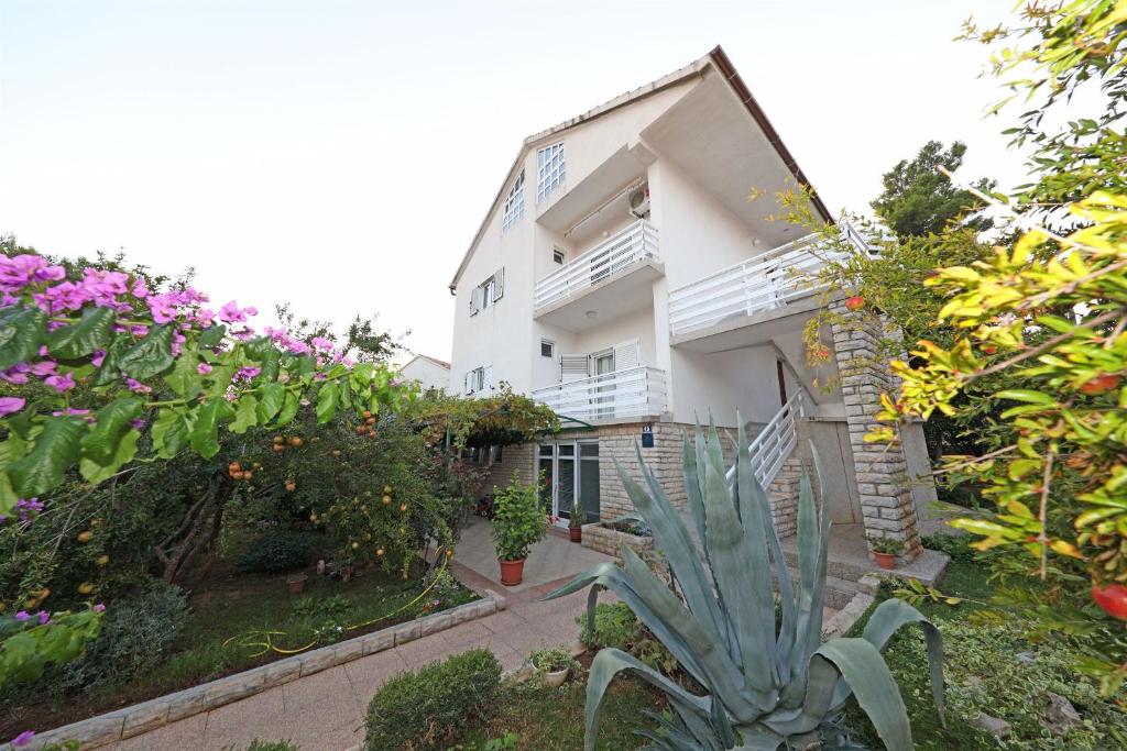 a white building with flowers in front of it at Apartments Sanja in Vodice