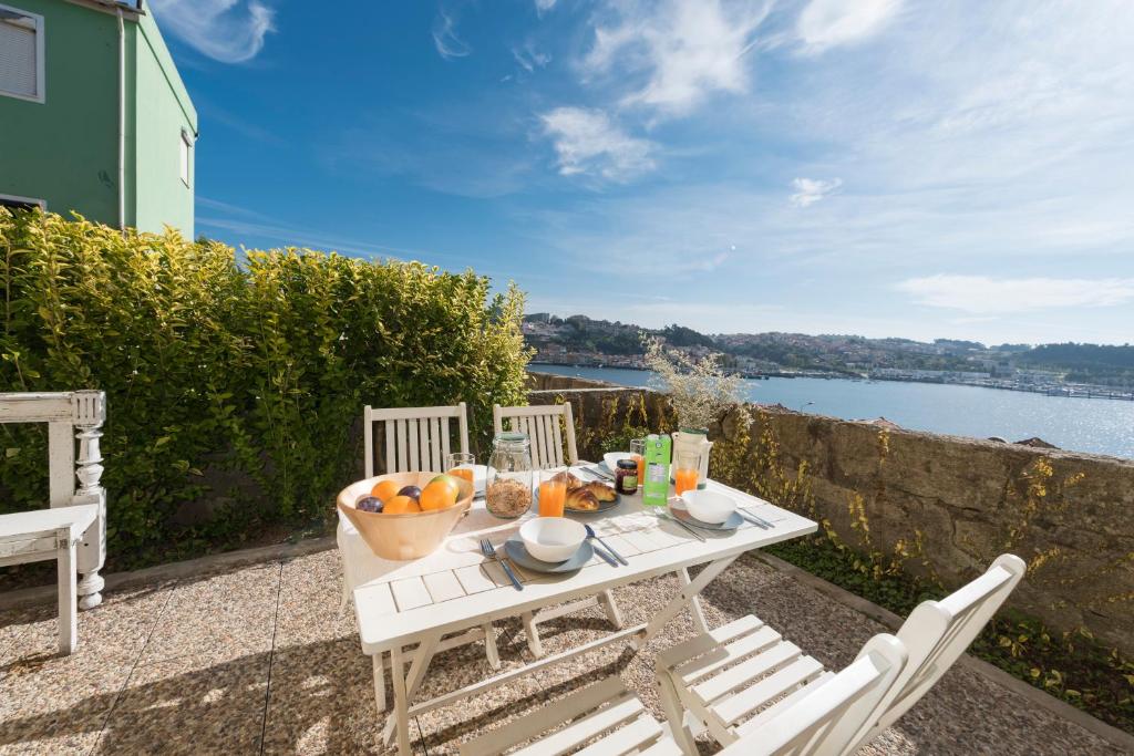 un tavolo bianco con un cesto di frutta sopra di Porto D'Ouro Apartment a Porto