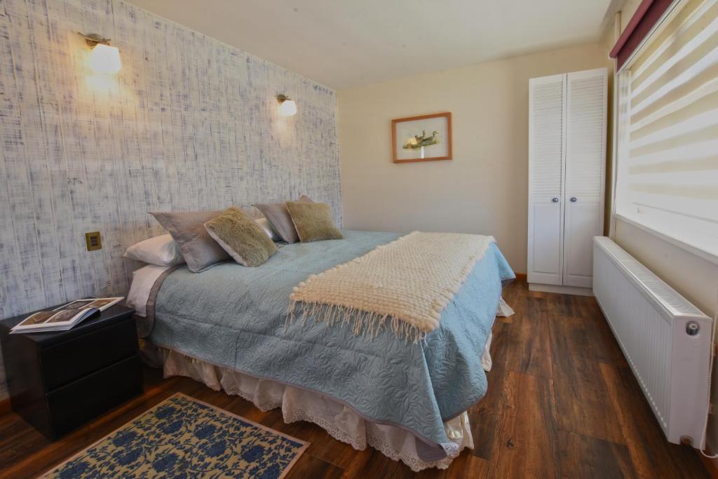 1 dormitorio con 1 cama con edredón azul en Abriga Bed and Breakfast, en Coyhaique