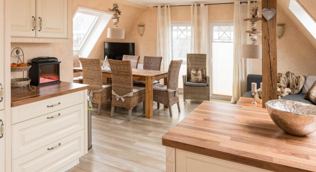 uma cozinha e sala de estar com uma mesa e uma sala de jantar em Altes Strandhus Casa Meeresrauschen em Scharbeutz