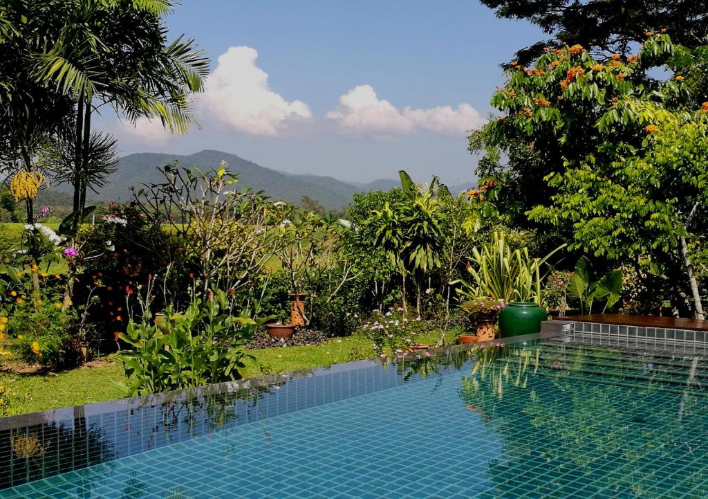 a swimming pool with a view of a garden at Villa Albizia in Chiang Mai in Doi Saket