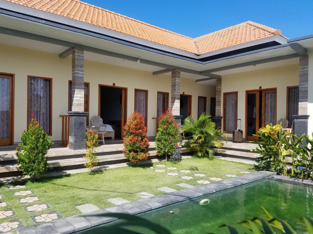 a house with a pool in front of it at Cantika Guest House in Uluwatu