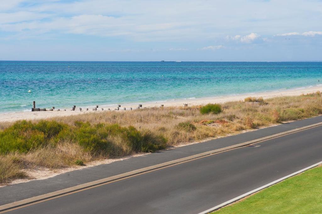 a road next to a beach with the ocean at Bayside Beauty in Busselton