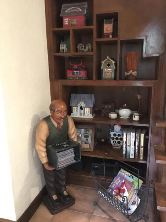 Eine Statue eines Mannes, der vor einem Bücherregal steht. in der Unterkunft La Famille Canyon Woods Tagaytay in Balibaguhan