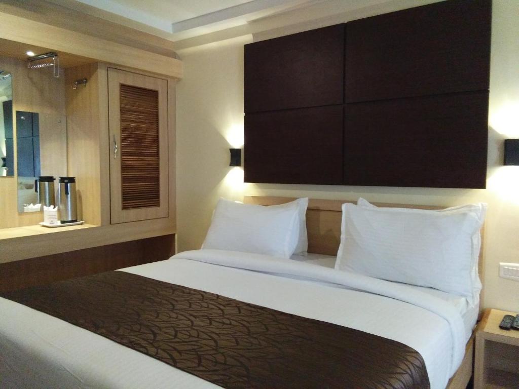 a hotel room with a large bed with white pillows at Darshan Resorts Pvt ltd in Ooty