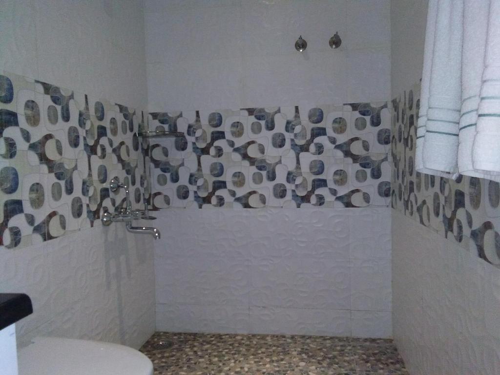 a bathroom with a shower with a toilet at Darshan Resorts Pvt ltd in Ooty