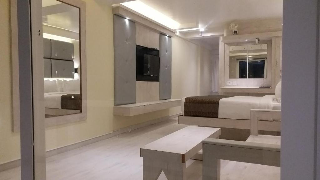 a bedroom with a bed and a large mirror at Darshan Resorts Pvt ltd in Ooty