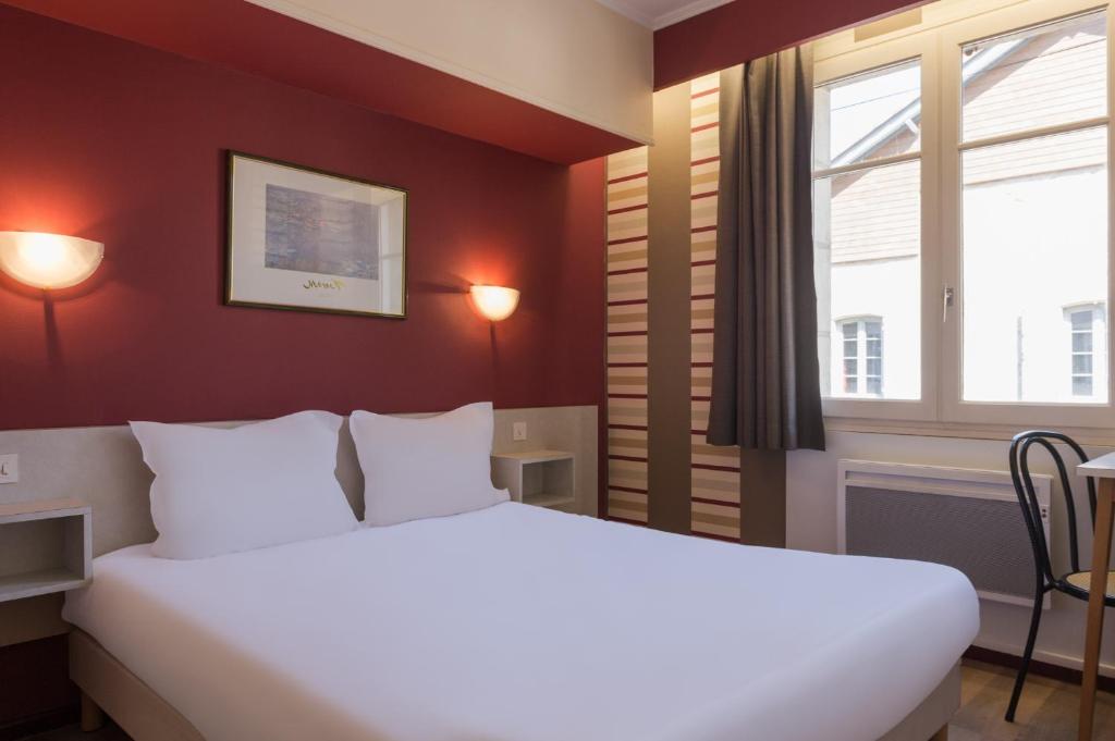 Un dormitorio con una gran cama blanca y una ventana en The Originals Access, Hôtel Figeac, en Figeac