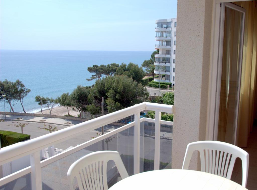 balcón con mesa, sillas y vistas al océano en Rentalmar Calas de Miami, en Miami Platja