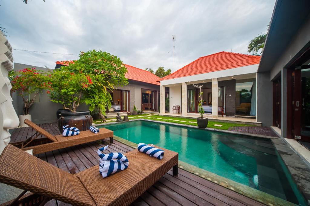een villa met een zwembad en een huis bij Casa Priya Canggu in Canggu